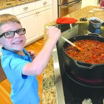 Keegan Walls stirring his spaghetti sauce.