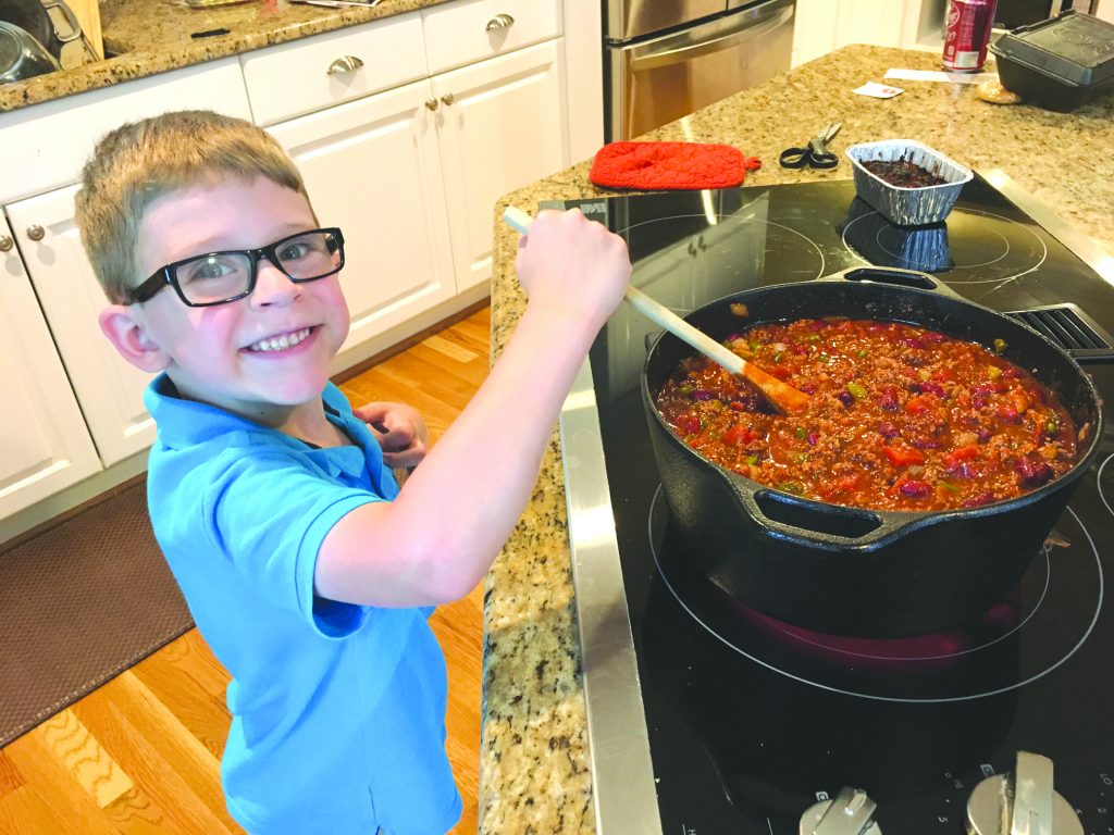 Keegan Walls stirring his spaghetti sauce.